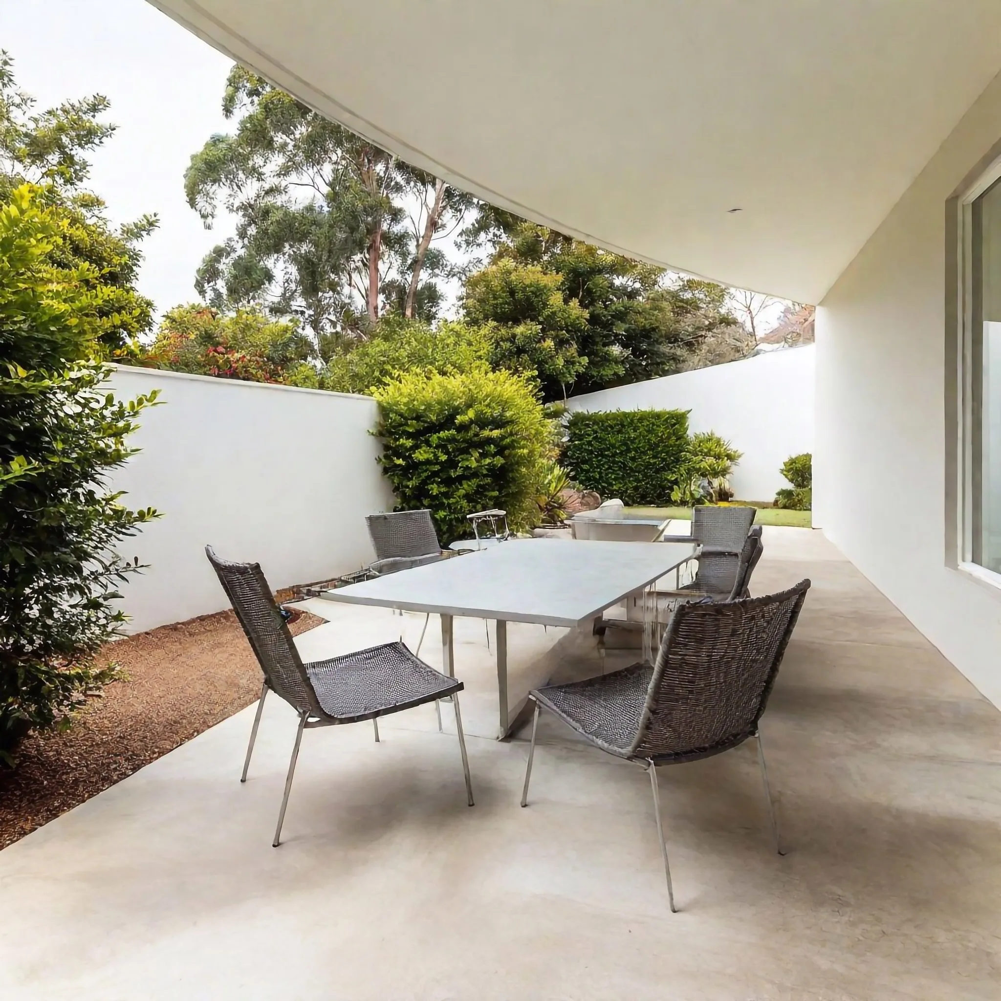 Concrete patio with outdoor dining setting in a Pakenham backyard