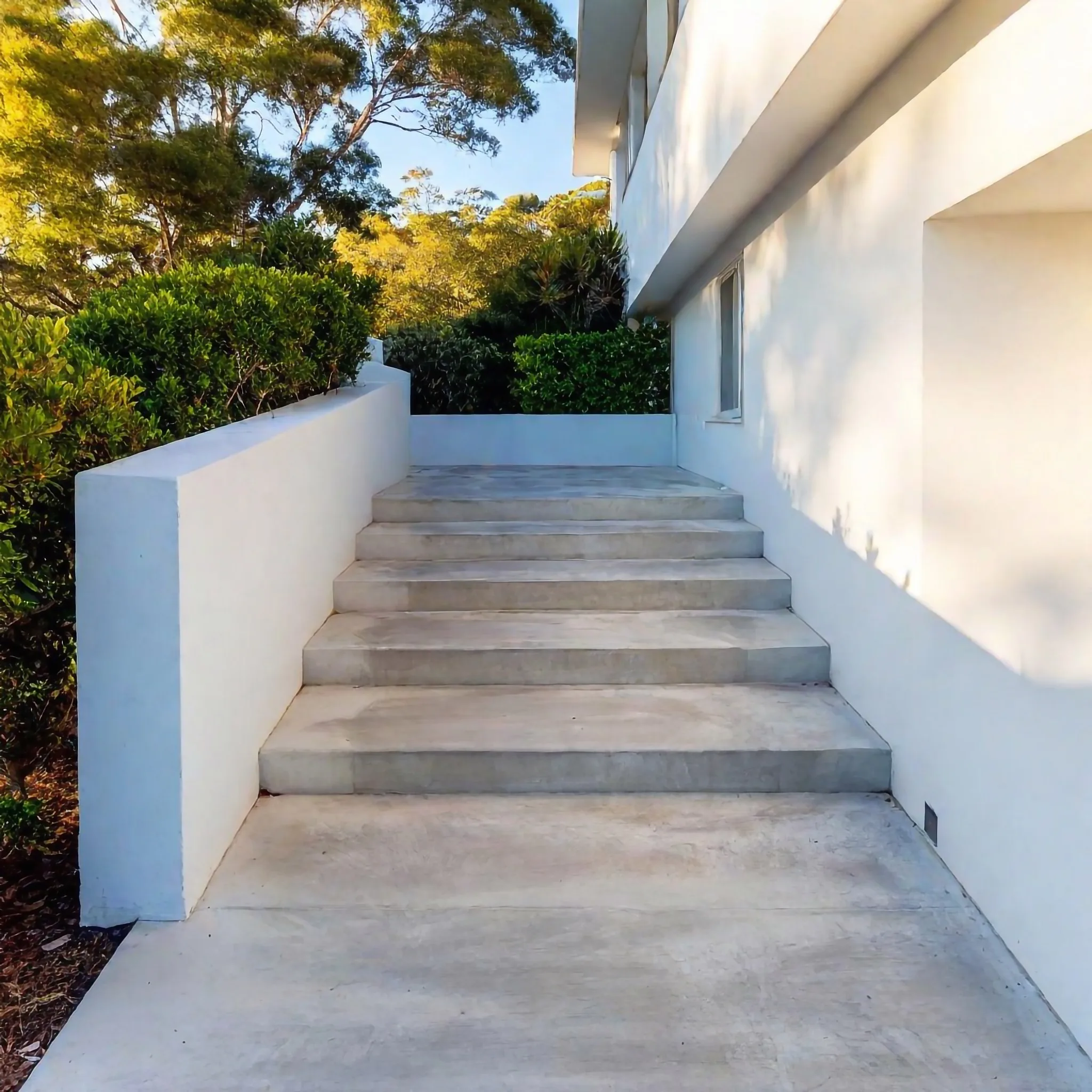 Concrete steps with a retaining wall leading to an entrance